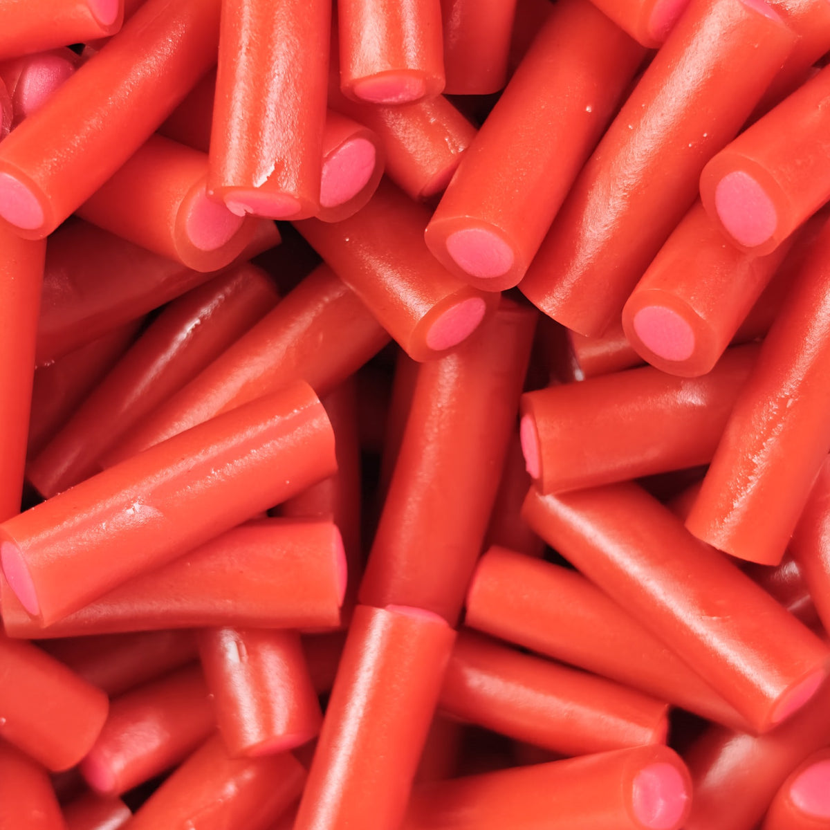 Toms Jordgubbskablar: thick strawberry chew pencils with a soft filled centre. Bulk pick & mix candy, shipped worldwide 